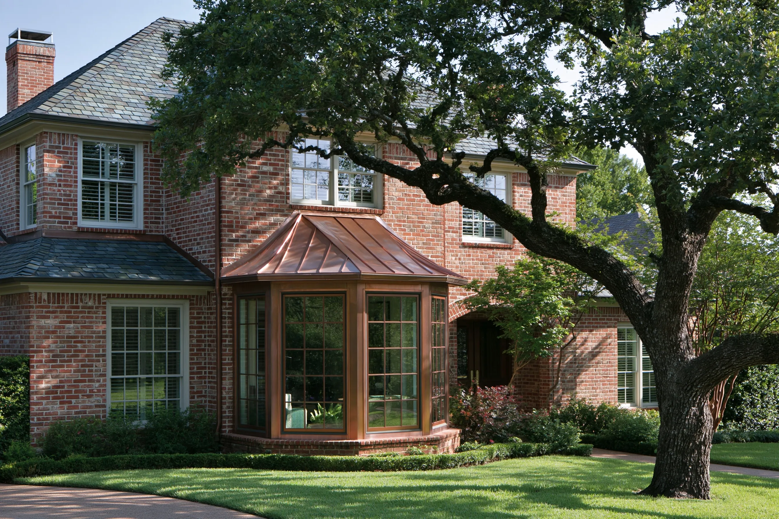 Copper standing-seam roof over a bay window on a red-brick two-story house